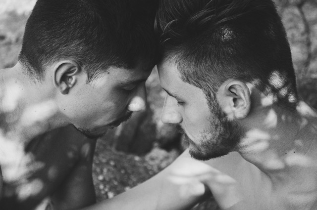 Two people sitting close together, engaged in an easy conversation, representing queer and LGBTQ relationships